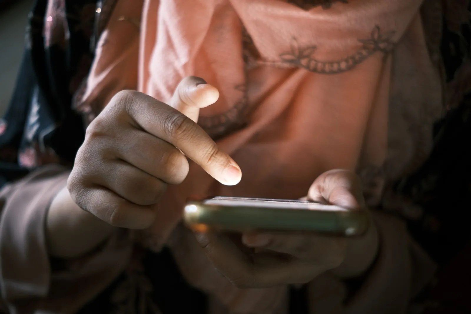 Close-up of a person's hands typing a message on a phone