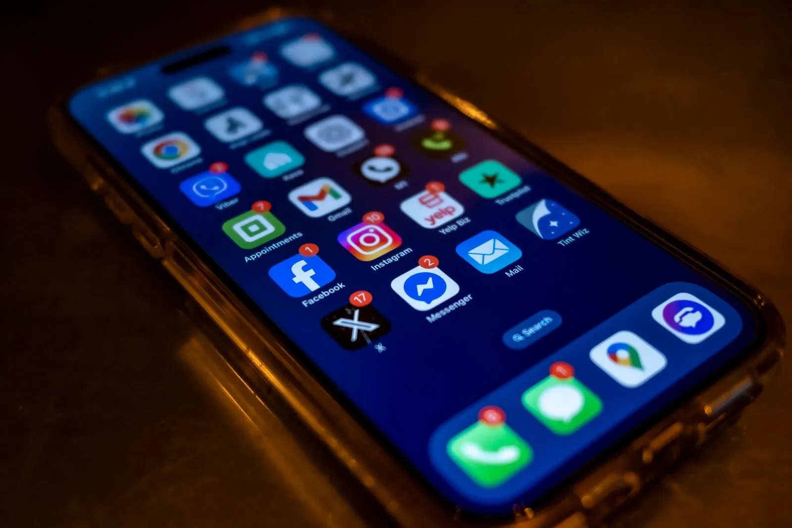 A phone home screen with unread notification badges stacked across every messaging and social app